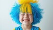 © Rodica - funny child with down syndrome in a blue and yellow wig, colors symbol of down syndrome, white background.
