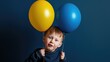 Little boy with two blue and yellow balloons, colors symbol of World Down Syndrome Day.  Autism, disability, solidarity, awareness, campaign. Children disability