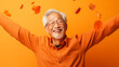 © Emre Akkoyun - Happy senior asian man on orange background with flying autumn leaves