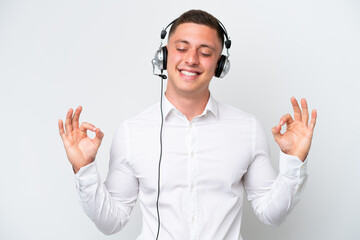 Wall Mural - Telemarketer Brazilian man working with a headset isolated on white background in zen pose