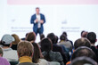 © Anton Gvozdikov - Rear view of audience watching a blurred presenter at a professional business conference seminar.