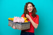 Young caucasian woman holding a clothes basket isolated on blue background celebrating a victory