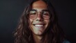© Z A C - Young person with long hair and glasses smiling at the camera with a warm and inviting expression.