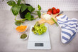 Food scale on a kitchen top, the digital display shows that the lettuce  on the dish weighs 19 grams.