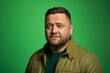 © Iigo - Portrait of a man in a green jacket on a green background