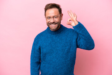 Wall Mural - Middle age caucasian man isolated on pink background showing ok sign with fingers