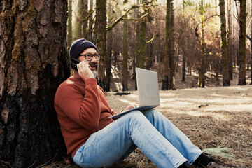 Canvas Print - One man using technology connection in nature park forest woods. Remote worker small travel business lifestyle people. Working in the nature alternative office. Small business. Travelers job life