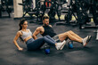 © Dusan Petkovic - Fit sporty couple sitting on a gym floor and doing exercises with kettlebell.