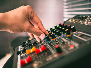 Close-up of sound engineer hands adjusting control sound mixer in recording, broadcasting studio,Sound mixer. Professional audio mixing console, buttons, faders and sliders. sound check.