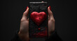 hand holding a black phone with a red heart valentine new concept
