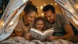 © buraratn - family, hygge and people concept - happy mother, father and little daughter reading book with torch light in kids tent at night at home