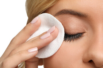 Wall Mural - Woman removing makeup with cotton pad on white background, closeup