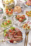 Fototapeta  - Easter breakfast with traditional sausage and cold cuts, deviled eggs and salads on festive table