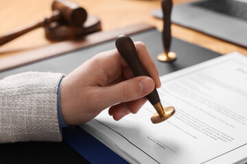 Canvas Print - Notary stamping document at table, closeup view