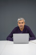 © Cultura Creative - Portrait of mature businessman working on laptop in office