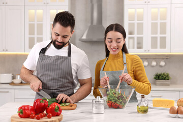 Poster - Lovely young couple cooking together in kitchen