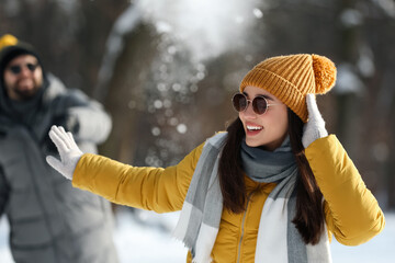 Wall Mural - Happy couple playing snowballs on winter day outdoors