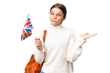 Poster - Teenager student caucasian girl holding an United Kingdom flag over isolated background having doubts while raising hands