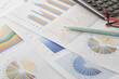 © aorphoto - graphs and charts. business reports and pile of documents with a coffee cup, glasses, pen, calculator place on desk.