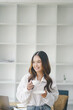 © Kiattiporn - Beautiful young concentrated business woman wearing shirt using laptop while standing in modern workspace