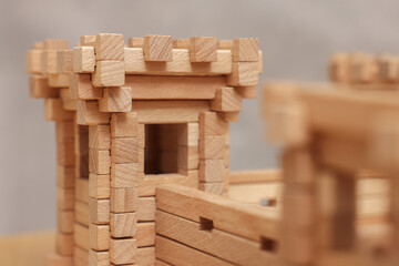 Sticker - Wooden fortress against grey background, closeup. Children's toy