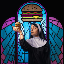 Nun Holding A Burger
