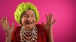 canvas print picture - Surprised happy winner fisheye view of funny elderly woman with no teeth and green hat isolated on pink background. Caricature of peoples emotions.