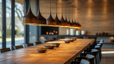 Fototapeta Konie - A dining area with a long, wooden table and a row of identical pendant lights hanging above. 