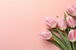 HD photograph capturing the elegance of tulips in full bloom on a pastel peach background, offering a seamless area for text integration.