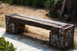 Wooden park benches are made from logs and stones.