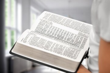 Poster - Christian concept. Young person reading Holly Bible book