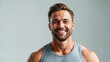 © The A.I Studio - man wearing gym clothes stands confident smiling while looking at the camera on a clean background