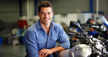 Handsome Motorcyclist Looking At Camera In A Motorcycle Repair Shop