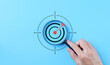 © Supatman - Business goals and target success concepts. Holding a magnifying glass with bullseye icon. Aim business, Business Growth, Goal objective strategy plan action, Target success, achievement company,