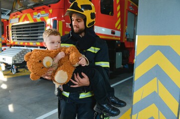 Wall Mural - Firefighter holding child boy to save him in fire and smoke,Firemen rescue the boys from fire