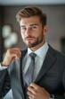 © Sean Maxhell - elegante uomo d'affari che si sistema la cravatta