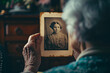 © vejaa - Elderly woman looks at vintage photo of her childhood portrait. Senior lady holding in hand old photo frame. Memories, nostalgia, family album