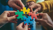 © Studio Nova - several hands of diverse people coming together to connect pieces of a multicolored jigsaw puzzle, symbolizing teamwork and collaboration.