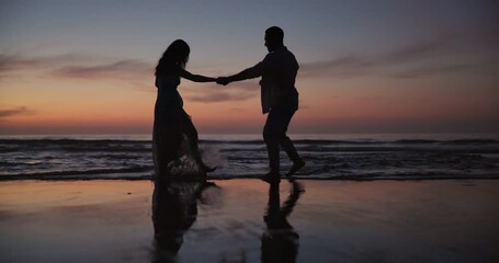 Wall Mural - Couple, silhouette and dancing or holding hands on beach for bonding, water splash or fun outdoor evening together. Man and woman enjoying waves on ocean coast at night for holiday weekend in nature