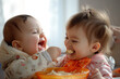 A baby being fed by her older sibling.