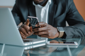 Poster - A man in a suit is using a cell phone next to a laptop