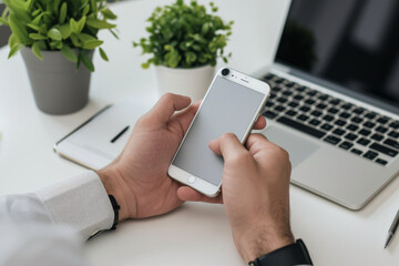Poster - A person holding an apple iphone in front of a laptop