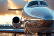 Front of a beautiful luxury private jet with chrome front close up view at sunset with space for text or inscriptions
