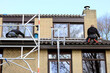 © corlaffra - Service engineers installing solar panels on a roof of a residential house