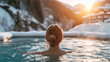 A woman enjoys a warm hot spring or spa pool, with steam rising around her, backed by snow-covered mountains and trees in a winter setting during sunset. Ai generative