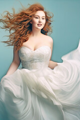 Wall Mural - Young redhead full-figured bride in a flowing white wedding dress in teal background. Concept of bridal joy, natural beauty, grace, femininity, and elegant simplicity.