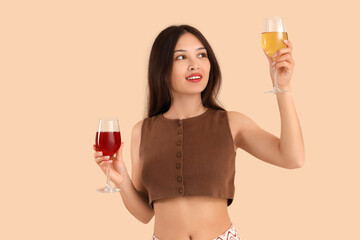 Sticker - Young Asian woman with glasses of wine on beige background