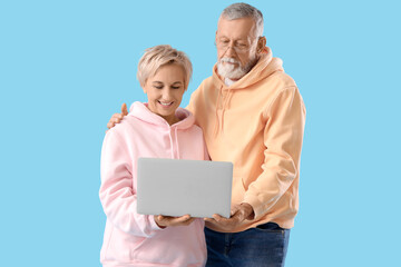 Poster - Mature couple with laptop on blue background