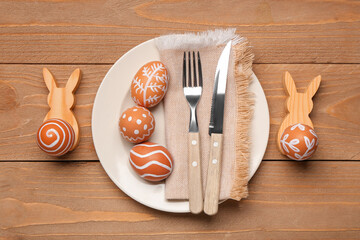 Poster - Beautiful table setting with painted Easter eggs, napkin and cutlery on wooden background