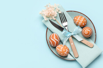 Poster - Stylish table setting with Easter eggs, napkin and cutlery on blue background